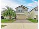 Charming two-story home boasts a well-manicured lawn, paver driveway, and attached two-car garage at 9917 Ivory Dr, Ruskin, FL 33573