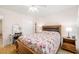 Comfortable bedroom with a floral-patterned quilt, ceiling fan, and bright natural lighting at 10034 64Th N Ave # 14, St Petersburg, FL 33708