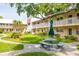 Building exterior showing the lush green landscape and exterior seating available to residents at 10034 64Th N Ave # 14, St Petersburg, FL 33708