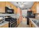 Well-lit kitchen features stainless steel appliances, granite countertops, wood cabinets, and tile flooring at 10034 64Th N Ave # 14, St Petersburg, FL 33708