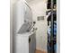 Efficient laundry area with stacked washer and dryer and shelving for organized storage at 10034 64Th N Ave # 14, St Petersburg, FL 33708