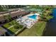 Aerial view of the sparkling swimming pool with lounge chairs and umbrellas by the lake at 10034 64Th N Ave # 14, St Petersburg, FL 33708
