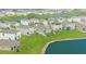 An aerial view showcases single-Gathering homes in a Primary-planned community with a tranquil lake and well-manicured green spaces at 10914 Penny Gale Loop, San Antonio, FL 33576
