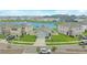 Aerial view of home surrounded by a lush green lawn and neighborhood lake at 10914 Penny Gale Loop, San Antonio, FL 33576