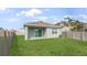 Backyard featuring a well-maintained lawn, private fence, and covered patio at 10914 Penny Gale Loop, San Antonio, FL 33576