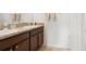 Bathroom featuring double sinks, wood cabinets and granite counters at 10914 Penny Gale Loop, San Antonio, FL 33576