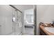 Bright bathroom with a walk-in shower, modern fixtures, and a view into the Primary bedroom at 10914 Penny Gale Loop, San Antonio, FL 33576
