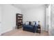 Cozy bedroom with a comfortable chair, bedside table, and window with natural light at 10914 Penny Gale Loop, San Antonio, FL 33576