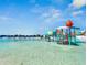 The community lagoon has shallow, clear blue water with beach chairs and a water park with slides for Gathering fun at 10914 Penny Gale Loop, San Antonio, FL 33576