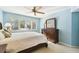 Serene bedroom features blue walls, soft lighting, and plantation shutters for privacy at 11440 Harbor Way # 5009, Largo, FL 33774