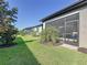 Well-maintained backyard with manicured lawn and lush landscaping along the home's screened lanai at 120 Moscata Way, Nokomis, FL 34275