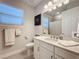 This bathroom features a granite countertop, white cabinets, and modern fixtures at 120 Moscata Way, Nokomis, FL 34275