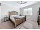 This bedroom features an ornate wood bed frame, plush carpeting, and a ceiling fan for added comfort at 120 Moscata Way, Nokomis, FL 34275