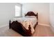 The bedroom features a wooden bed frame with a patterned bedspread and carpeting at 120 Moscata Way, Nokomis, FL 34275