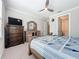 Bedroom showcasing a wooden dresser and bed with a patterned quilt near the doorway at 120 Moscata Way, Nokomis, FL 34275
