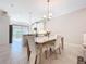 Open concept dining area with modern table and chairs, flowing into a bright kitchen at 120 Moscata Way, Nokomis, FL 34275