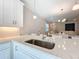 Modern kitchen features a large sink, white cabinets, and an open layout into the living area at 120 Moscata Way, Nokomis, FL 34275