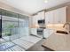 Well-lit kitchen with white cabinetry, modern appliances, and seamless access to the outdoor area through sliding doors at 120 Moscata Way, Nokomis, FL 34275