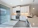 Bright kitchen featuring white cabinetry, stainless steel appliances, and sliding glass doors for natural light at 120 Moscata Way, Nokomis, FL 34275