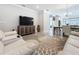 Open concept living room with modern furniture, TV, and seamless transition to the dining and kitchen areas at 120 Moscata Way, Nokomis, FL 34275