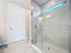 Modern glass shower featuring sleek tilework, a shower seat, and abundant natural light at 120 Moscata Way, Nokomis, FL 34275