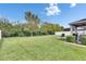 Expansive backyard featuring lush green grass, full perimeter fence, and a seating area with an umbrella at 12328 Streambed Dr, Riverview, FL 33579