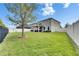 Lush backyard featuring a large lawn, a patio, and white fencing, offering privacy and space at 12328 Streambed Dr, Riverview, FL 33579