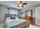 Cozy bedroom features a wood bed frame, ceiling fan, and natural light from the window at 12328 Streambed Dr, Riverview, FL 33579