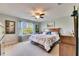 Bedroom featuring large window, wooden bed frame, and neutral color scheme at 12328 Streambed Dr, Riverview, FL 33579