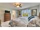 Bedroom includes a window, ceiling fan, television, and en-suite bathroom access at 12328 Streambed Dr, Riverview, FL 33579