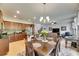 Open-concept dining area with a chandelier, wood table and chairs, with open view to the kitchen and living room at 12328 Streambed Dr, Riverview, FL 33579