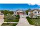 Beautifully landscaped two-story home with a brick driveway, three-car garage, and vibrant green lawn at 12328 Streambed Dr, Riverview, FL 33579