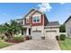 Charming two-story home with a well-manicured lawn, brick driveway, and inviting curb appeal at 12328 Streambed Dr, Riverview, FL 33579
