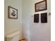 Simple half-bathroom with toilet, pedestal sink, decorative mirror, and neutral color scheme at 12328 Streambed Dr, Riverview, FL 33579
