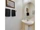 Simple half-bathroom with pedestal sink, decorative mirror, and neutral color scheme at 12328 Streambed Dr, Riverview, FL 33579