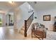Inviting hallway featuring tile flooring, staircase with wood banister, and views into other rooms at 12328 Streambed Dr, Riverview, FL 33579