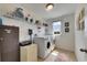 Well-equipped laundry room includes modern washer and dryer, shelving, and a window at 12328 Streambed Dr, Riverview, FL 33579