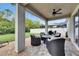Covered patio featuring a ceiling fan, elegant lounge seating, and view of the expansive, fenced backyard at 12328 Streambed Dr, Riverview, FL 33579