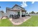 Outdoor patio with dining and lounge seating, brick pavers, and a lush lawn creating an inviting backyard space at 12328 Streambed Dr, Riverview, FL 33579