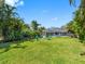 Lush backyard featuring a screened-in pool, a firepit, and tropical landscaping at 13420 Rustic Pines S Blvd, Seminole, FL 33776