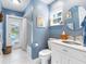 Charming bathroom with blue walls, white vanity, and direct access to the pool area at 13420 Rustic Pines S Blvd, Seminole, FL 33776