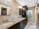 Bathroom featuring granite counters, double sinks, and storage cabinets at 13420 Rustic Pines S Blvd, Seminole, FL 33776