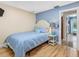 Cozy bedroom with light blue accents, wood floors, and adjoining bathroom access at 13420 Rustic Pines S Blvd, Seminole, FL 33776
