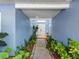 Charming entryway with lush tropical landscaping and a welcoming double-door entrance at 13420 Rustic Pines S Blvd, Seminole, FL 33776
