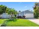 Charming single-story home with a well-manicured lawn, tropical landscaping, and a two-car garage at 13420 Rustic Pines S Blvd, Seminole, FL 33776