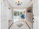 Elegant foyer with glossy tiled floors, chandelier, and view of the pool area at 13420 Rustic Pines S Blvd, Seminole, FL 33776