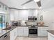 Bright kitchen features stainless steel appliances, granite counters, and white cabinetry at 13420 Rustic Pines S Blvd, Seminole, FL 33776