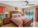 Well-lit main bedroom boasts a ceiling fan, a walk-out to the pool, and wood floors at 13420 Rustic Pines S Blvd, Seminole, FL 33776