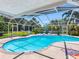 Stunning screened-in pool area with lush landscaping and ample lounge seating at 13420 Rustic Pines S Blvd, Seminole, FL 33776