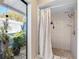 Shower with pebble stone flooring, shower head, and privacy curtain at 13420 Rustic Pines S Blvd, Seminole, FL 33776